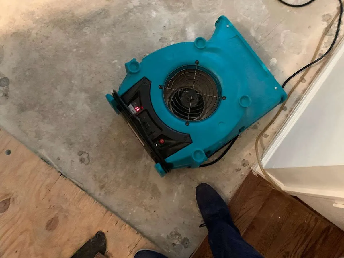 Air mover drying subfloor during Leak Detection & Repair in Marquette